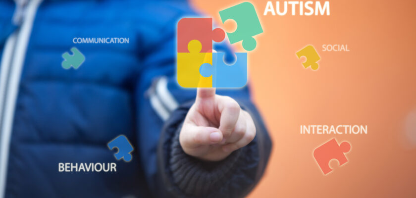 Child connecting autism awareness puzzle by pressing icons on digital virtual screen.
