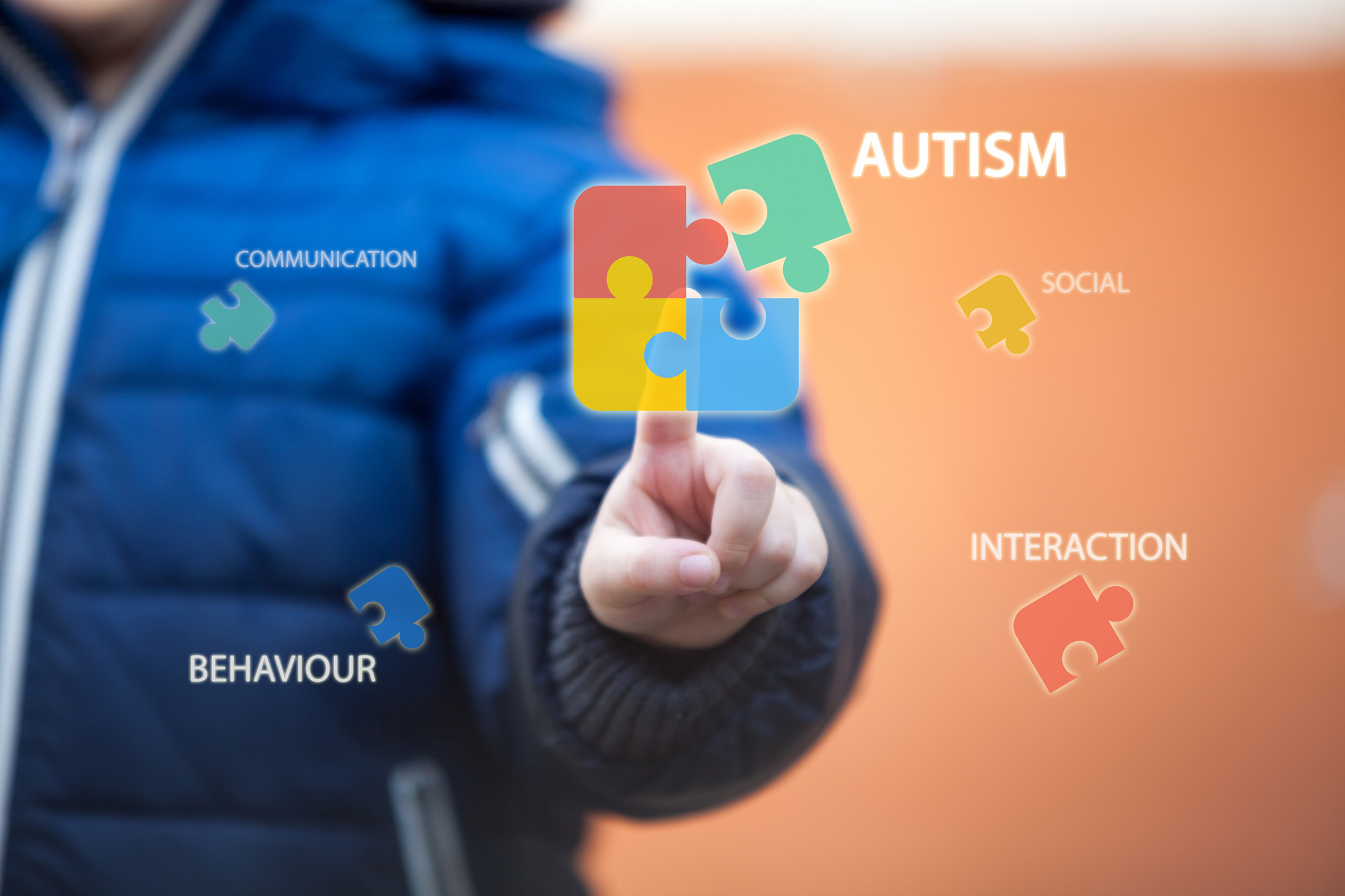 Child connecting autism awareness puzzle by pressing icons on digital virtual screen.