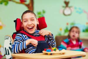 Cheerful boy with disability at rehabilitation center for kids with special needs