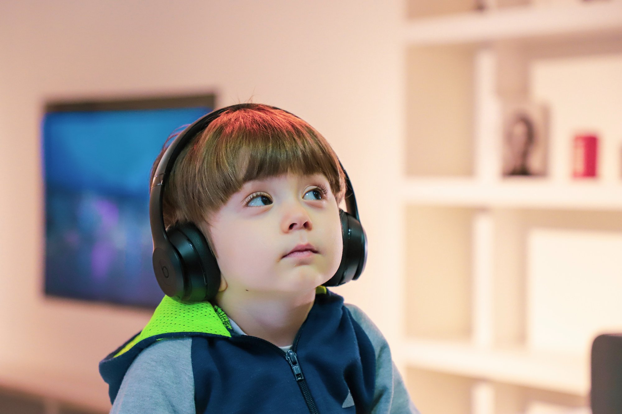 A small child wearing headphones could have one of the many types of developmental disabilities.