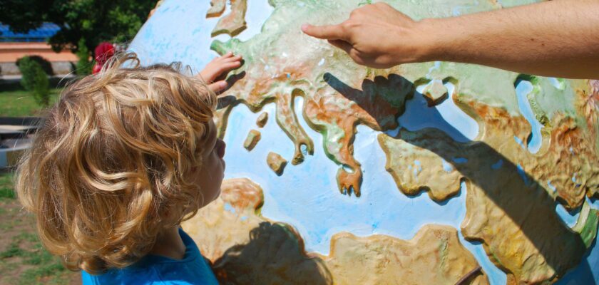 A young boy examining a large globe