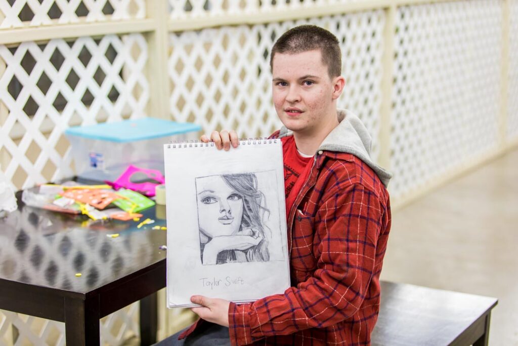 man holding an art piece he created