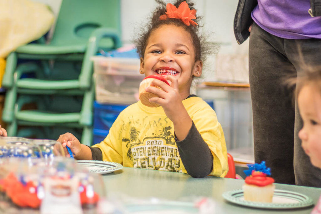 smiling girl eating a cupcake